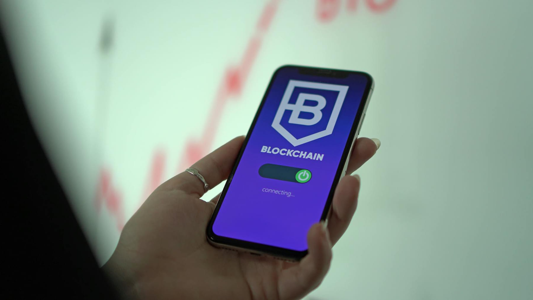 Hand holding smartphone displaying blockchain cryptocurrency wallet. on Quest on Chain