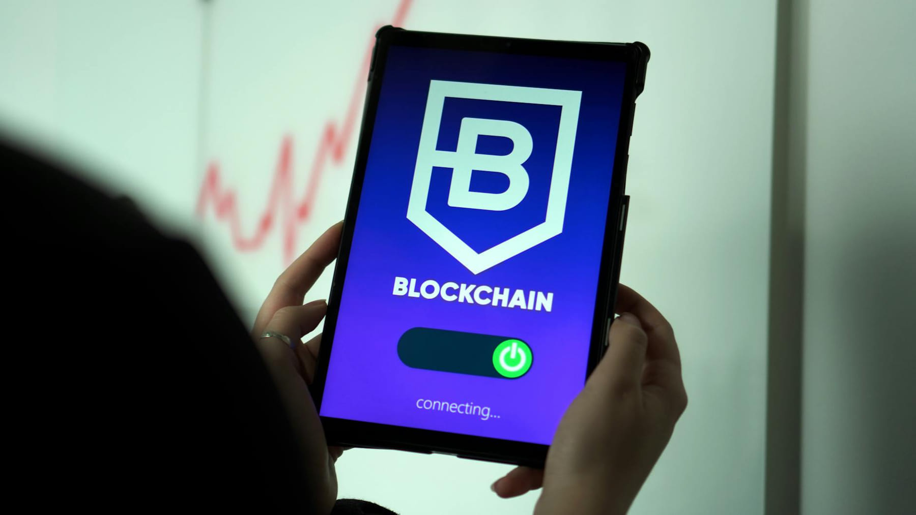 Close-up of hands holding a tablet displaying a blockchain application interface. on Quest on Chain