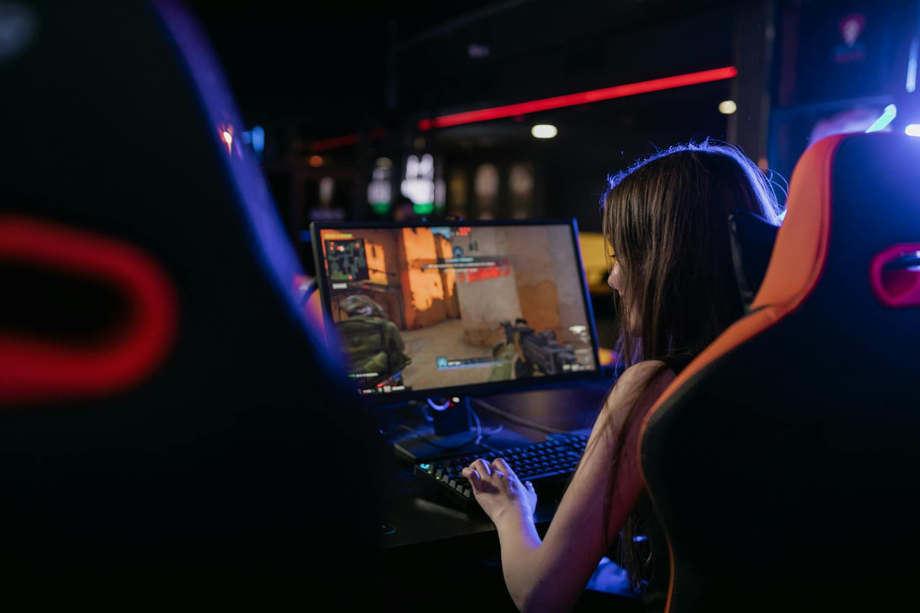 A woman is deeply engaged in playing computer games indoors, highlighting the gaming lifestyle. on Quest on Chain