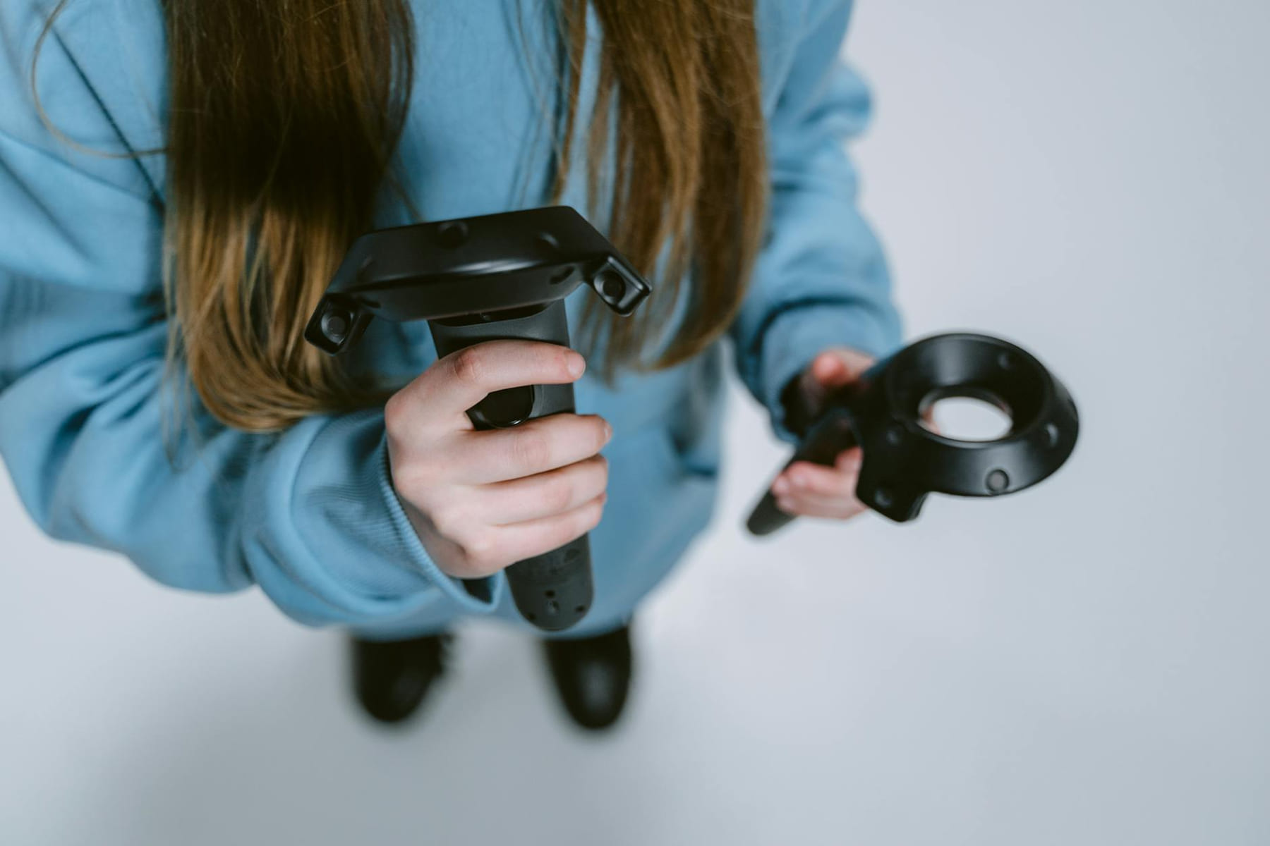 Detailed view of a person holding virtual reality controllers, engaging in immersive gaming. on Quest on Chain