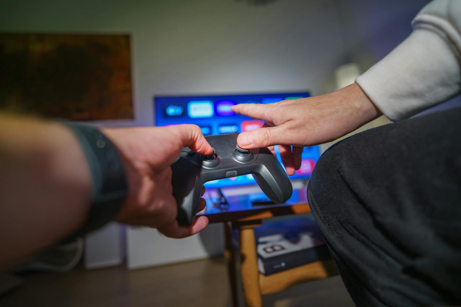 Close-up of hands using a game controller in a cozy living room setting. on Quest on Chain