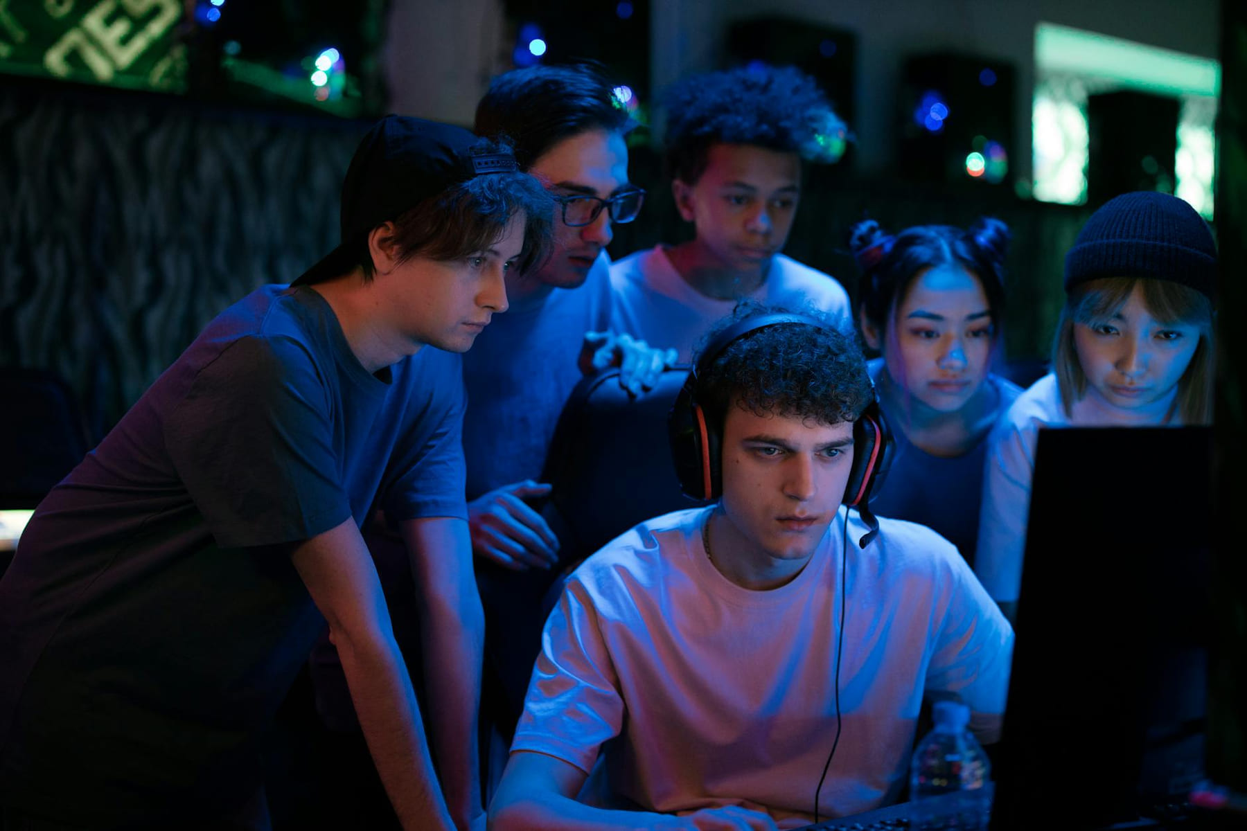 Group of diverse teenagers gaming together indoors, intense and focused. on Quest on Chain