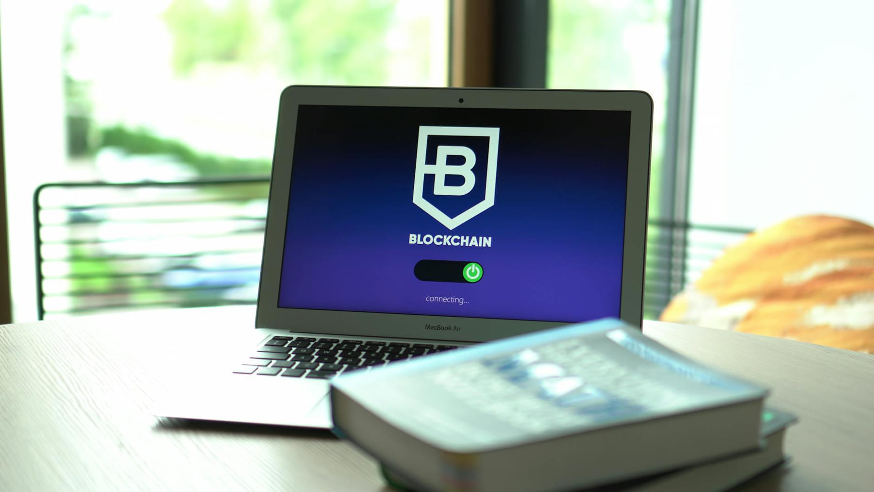 Laptop displaying blockchain connecting screen in modern setting. on Quest on Chain
