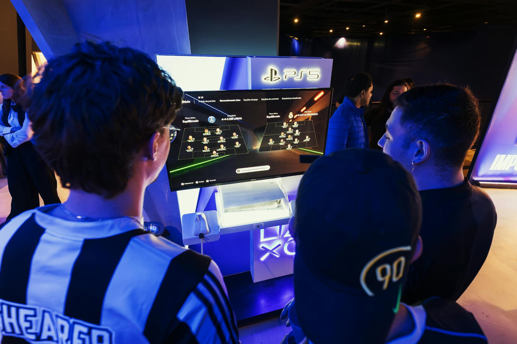 Group of gamers engaged in a PS5 event, choosing teams on a football game selection screen. on Quest on Chain