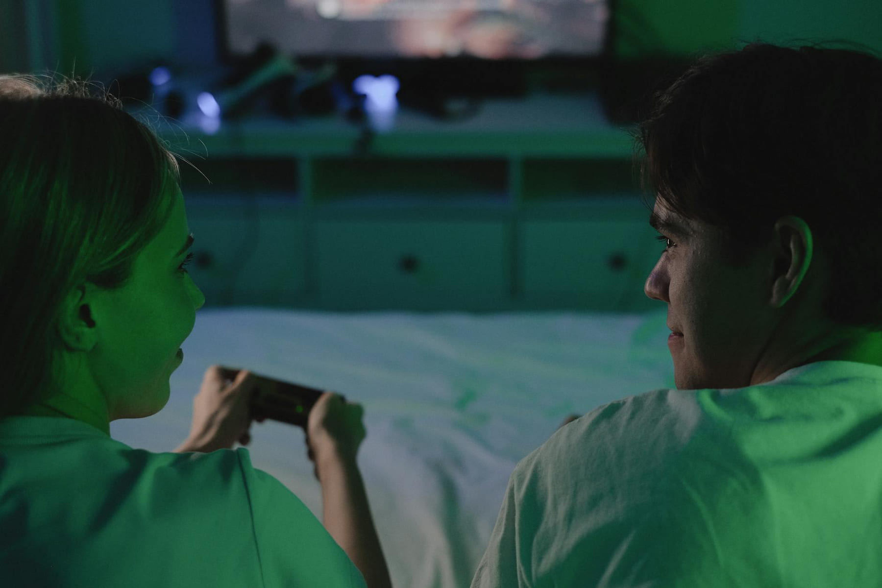 A couple enjoying a video game together in a dimly lit bedroom setting. on Quest on Chain