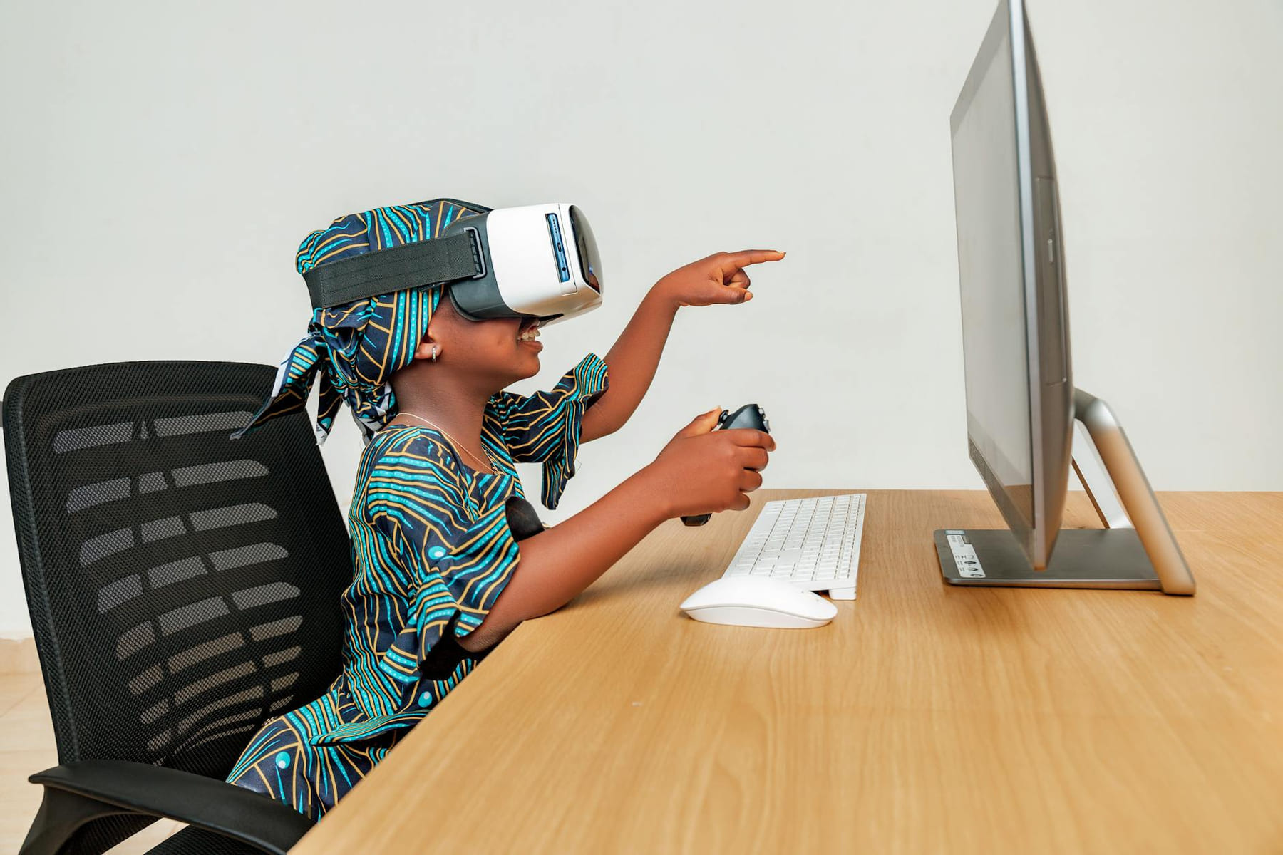 Young child using a VR headset and controller at a desk, engaging with technology. on Quest on Chain