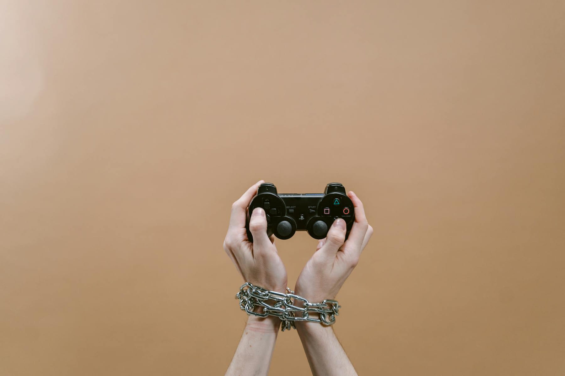 Conceptual image of hands in chains holding a game controller symbolizing gaming addiction. on Quest on Chain