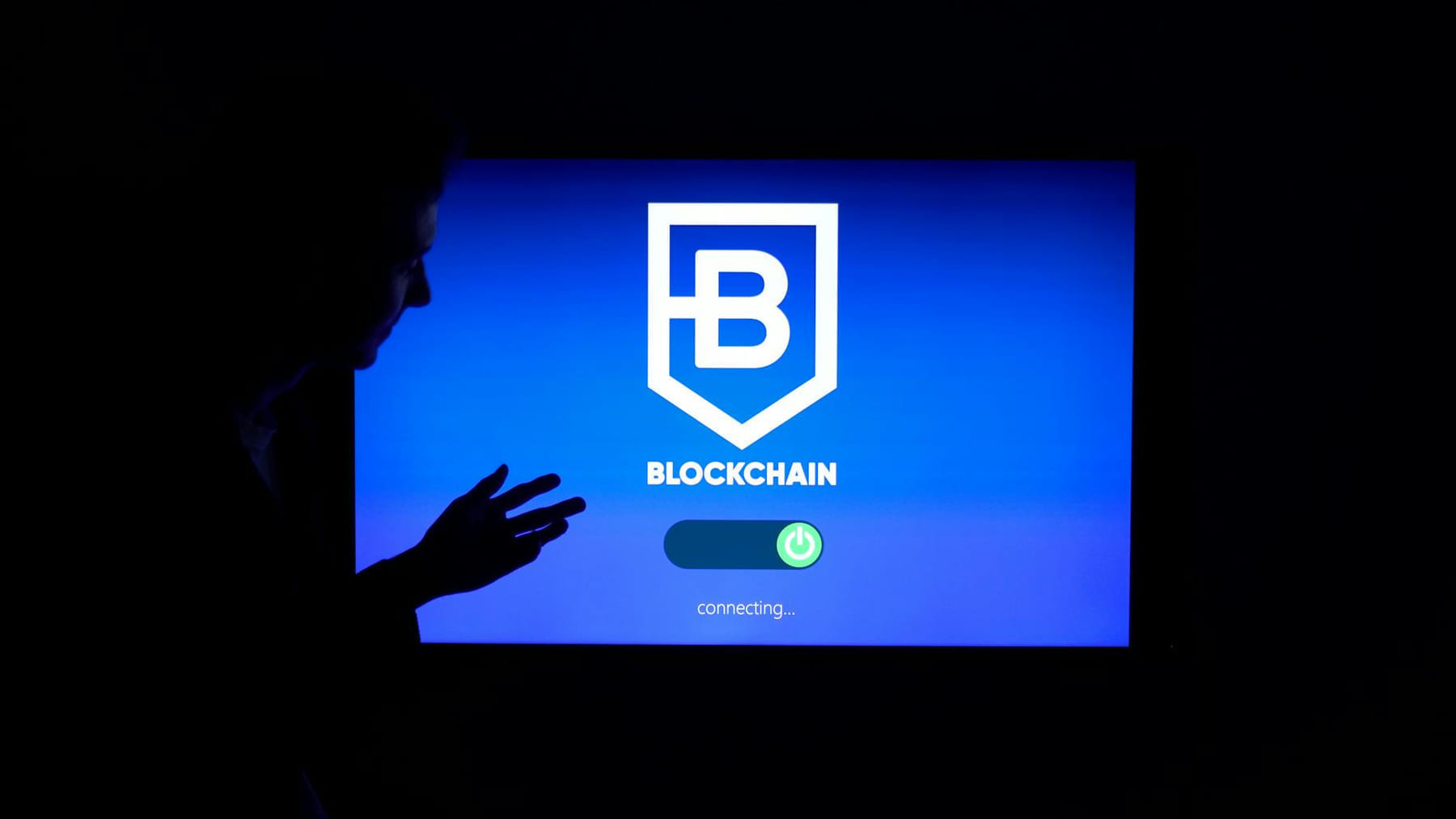 Silhouette of a person interacting with a blockchain technology display screen, showcasing digital innovation. on Quest on Chain