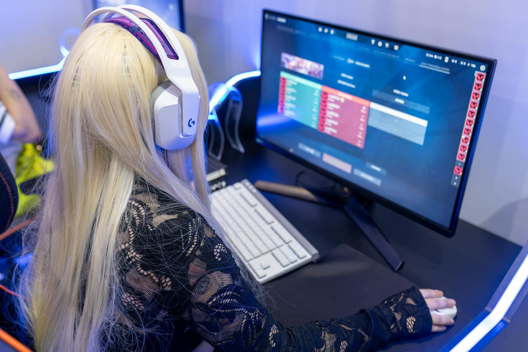 Young woman gaming at a PC high-tech setup, wearing headphones. on Quest on Chain