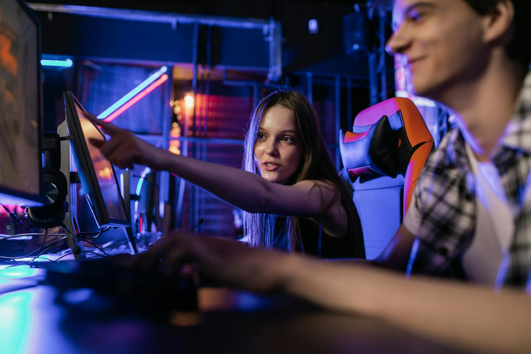 Teenagers engaging in a gaming session with illuminated monitors and vibrant LED lighting setup. on Quest on Chain