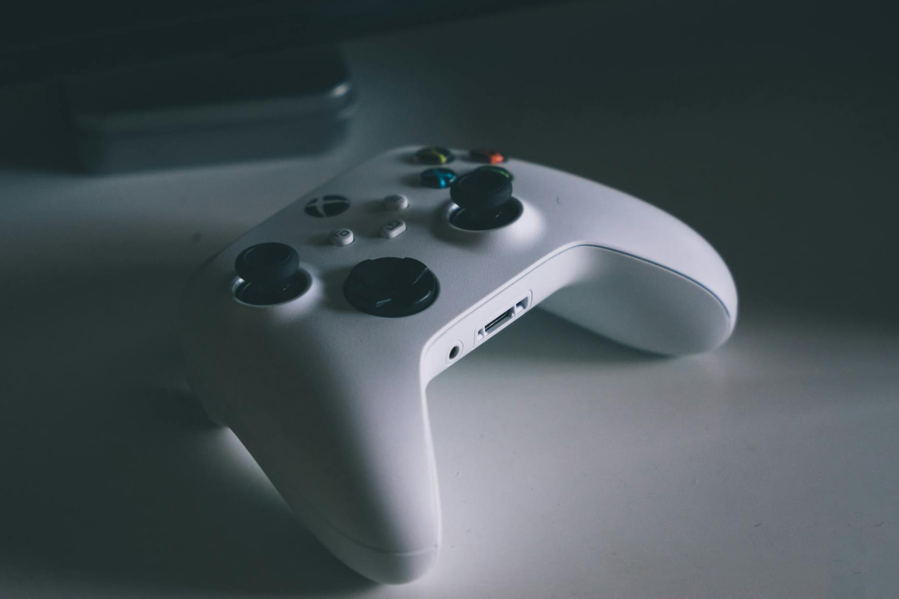 A detailed shot of a white gaming controller on a desk surface, perfect for tech and gaming themes. on Quest on Chain